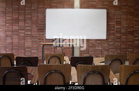 Leeres Klassenzimmer leerer Teacher`s Schreibtisch mit Whiteboard im Hintergrund. Kein Lehrer. Virtuelle Bildung. Keine Studenten. Klassenraum ohne Lehrer. Klassenraum ohne Schüler. Universitätsunterricht. Erwachsenenbildung Kindererziehung Kindererziehung Virtuelle Bildung Stockfoto